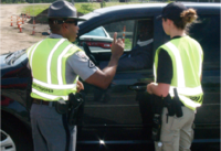 2 DPPPS officers training and standing outside a vehicle